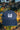 Blue-indigo washed cap with a white logo on a blurred natural background