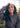 Woman wearing a dark gray hoodie with a blurred natural background