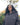 Woman wearing a dark hoodie with a logo outdoors