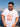 Man wearing a white t-shirt with orange text and graphics by a body of water.