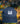 Blue-indigo washed cap with a white logo on a blurred natural background