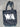 Black tote bag with 'WA' printed on it, lying on a textured surface.